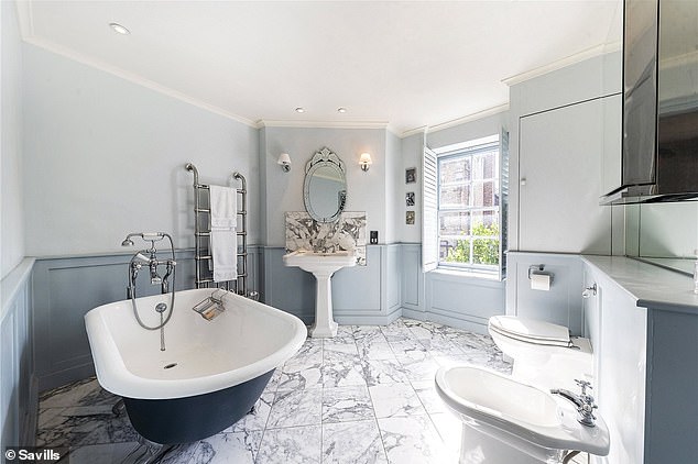 This bathroom at the property includes a roll top bath and a large window