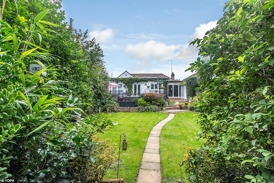 Pictured: The rear of the bungalow from the outbuilding at the end of the garden