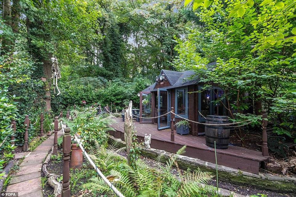 The garden path leads to an outbuilding that houses a bar and entertainment space